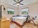 Comfortable bedroom features wood floors, a ceiling fan, and two windows offering plenty of natural light at 2160 Ne Coachman Rd, Clearwater, FL 33765
