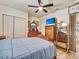 A bedroom has wood look tile flooring, a ceiling fan, and wood furniture at 2160 Ne Coachman Rd, Clearwater, FL 33765