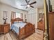 Bedroom featuring wood-look tile flooring, a ceiling fan and carved wood furniture at 2160 Ne Coachman Rd, Clearwater, FL 33765