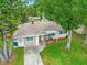 Attractive single-story home featuring a blend of stone and siding, a well-kept lawn, and mature trees at 2160 Ne Coachman Rd, Clearwater, FL 33765