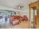 Cozy living room with hardwood floors, ceiling fan, comfortable leather seating, and adjacent dining area at 2160 Ne Coachman Rd, Clearwater, FL 33765