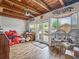 Bright and airy sun room featuring custom wood beam ceiling, plenty of natural light, and access to an outdoor space at 2160 Ne Coachman Rd, Clearwater, FL 33765
