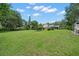 Expansive backyard featuring lush green grass, mature trees, and ample space for recreation and outdoor activities at 2306 S Valrico Rd, Valrico, FL 33596