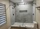 Bathroom with walk-in shower with a glass door, new tiling and upgraded shower head at 2306 S Valrico Rd, Valrico, FL 33596