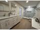 Bright bathroom featuring a double vanity, wood floors and a glass enclosed shower at 2306 S Valrico Rd, Valrico, FL 33596