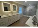 Bathroom featuring dual sinks, vanity with storage, a walk-in shower, and new lighting at 2306 S Valrico Rd, Valrico, FL 33596