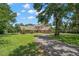 Charming brick home with a well-manicured lawn, complemented by mature trees and landscaping at 2306 S Valrico Rd, Valrico, FL 33596
