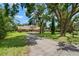 Charming brick home with a well-manicured lawn, complemented by mature trees and landscaping at 2306 S Valrico Rd, Valrico, FL 33596