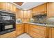 Kitchen with wood cabinetry, granite countertops, gas cooktop, oven, tile floors, and under cabinet lights at 2306 S Valrico Rd, Valrico, FL 33596