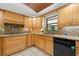 Bright kitchen features wood cabinetry, granite countertops, stainless steel appliances, and tile flooring at 2306 S Valrico Rd, Valrico, FL 33596