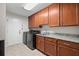 A spacious laundry room with granite countertop, dark wood cabinets, tile flooring, and modern black appliances at 2306 S Valrico Rd, Valrico, FL 33596