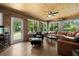 Spacious sun room with brick walls, wood ceiling, hardwood flooring, and multiple windows overlooking the pool at 2306 S Valrico Rd, Valrico, FL 33596