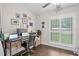 Bright office with a computer desk, fan, wood floors, and plantation shutters to the exterior at 2306 S Valrico Rd, Valrico, FL 33596