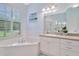Bright bathroom features a soaking tub, plantation shutters, and a vanity with ample counter space at 2435 Fox Forest Dr, Lutz, FL 33549
