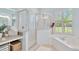 Bathroom with shower and soaking tub, featuring natural light through plantation shutters at 2435 Fox Forest Dr, Lutz, FL 33549