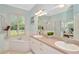 Bright bathroom featuring double sinks, soaking tub, walk-in shower, and shuttered window at 2435 Fox Forest Dr, Lutz, FL 33549