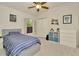 Comfortable bedroom with a ceiling fan, plush carpeting, and a window bringing natural light into the room at 2435 Fox Forest Dr, Lutz, FL 33549