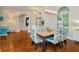 Formal dining room with hardwood floors, large windows, an elegant light fixture, and seating for four guests at 2435 Fox Forest Dr, Lutz, FL 33549