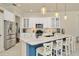Bright kitchen with white cabinets, stainless steel appliances, stylish pendant lighting, and a marble countertop island at 2435 Fox Forest Dr, Lutz, FL 33549