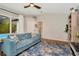 Cozy living room features a comfortable blue sofa, area rug, ceiling fan, and access to the pool area at 2435 Fox Forest Dr, Lutz, FL 33549
