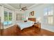 Bright main bedroom featuring hardwood floors, a ceiling fan, natural light, access to the pool and custom window shutters at 2435 Fox Forest Dr, Lutz, FL 33549