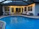 Outdoor patio area with a screened-in pool, dining table and comfortable seating at 2435 Fox Forest Dr, Lutz, FL 33549