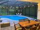 Wonderful backyard pool with a screened-in lanai, comfortable seating, and outdoor dining space with pretty string lights at 2435 Fox Forest Dr, Lutz, FL 33549