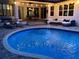 Tranquil poolside view with lounge chairs and exterior lighting at 2435 Fox Forest Dr, Lutz, FL 33549