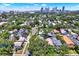 Aerial view shows neighborhood with tree-lined streets and city skyline in the background on a sunny day at 258 14Th Ne Ave, St Petersburg, FL 33701