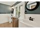 Bathroom featuring dual sinks, a clawfoot tub, wainscoting, and dark blue walls at 258 14Th Ne Ave, St Petersburg, FL 33701