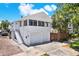 Bright exterior of the home featuring a two-car garage, well-maintained landscaping, and a side staircase at 258 14Th Ne Ave, St Petersburg, FL 33701