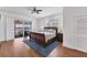 Comfortable bedroom featuring hardwood floors, ceiling fan and a private balcony with water views at 3 Pointe Way, Placida, FL 33946