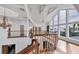 Second floor hallway featuring wood floors, modern lighting, and natural light from large windows at 3 Pointe Way, Placida, FL 33946