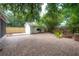 Serene backyard with brick patio, fire pit, and a charming shed, perfect for outdoor gatherings at 318 W Haya St, Tampa, FL 33603