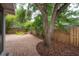 Lush backyard featuring a brick patio, mature trees, a charming fire pit, and a wooden fence at 318 W Haya St, Tampa, FL 33603