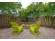 Charming backyard featuring a brick fire pit, green chairs, and lush landscaping for relaxation and entertaining at 318 W Haya St, Tampa, FL 33603