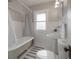 Classic bathroom features a clawfoot tub, pedestal sink, and white beadboard walls at 318 W Haya St, Tampa, FL 33603
