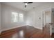 Minimalist bedroom with wood floors, white walls, two windows, and closet at 318 W Haya St, Tampa, FL 33603