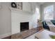 Close-up of a white brick fireplace with tile accents, complemented by hardwood floors and natural light at 318 W Haya St, Tampa, FL 33603