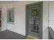 Charming front door with glass panes and a decorative wreath, set against white siding and a gray porch at 318 W Haya St, Tampa, FL 33603