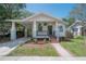 Charming bungalow with a cozy front porch and attached carport, showcasing curb appeal at 318 W Haya St, Tampa, FL 33603