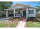 Quaint front porch of a charming bungalow with hanging plants and brick stairs at 318 W Haya St, Tampa, FL 33603