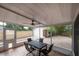 Enclosed patio features outdoor table and view of garage, brick pavers, and lush backyard at 318 W Haya St, Tampa, FL 33603