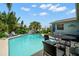 Backyard oasis showcasing a refreshing pool, dining set, and cozy lounge area surrounded by tropical greenery at 338 7Th N Ave, Tierra Verde, FL 33715