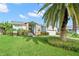 Charming single Gathering home featuring a landscaped front yard, a palm tree, and an inviting entrance at 338 7Th N Ave, Tierra Verde, FL 33715