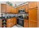Efficient kitchen with wood cabinets, dark granite counters, and stainless appliances at 338 7Th N Ave, Tierra Verde, FL 33715
