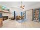 Bright living room features a fireplace, ceiling fan, and built-in shelving for storage and decor at 338 7Th N Ave, Tierra Verde, FL 33715