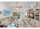 Spacious living area with a large TV, tile floors, and access to the lanai and pool at 338 7Th N Ave, Tierra Verde, FL 33715