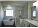 Bright bathroom with a soaking tub under a window and a glass enclosed tiled shower at 3405 Silver Glen Ct, Plant City, FL 33566