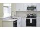 Updated kitchen featuring white cabinets, stainless steel appliances, stone countertops, and a sleek design at 3405 Silver Glen Ct, Plant City, FL 33566